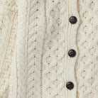 Cream Aran cardigan with buttons, front view.