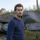 Man in blue sweater looking thoughtful