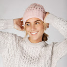 Woman wearing square pink mist beanie and sweater.